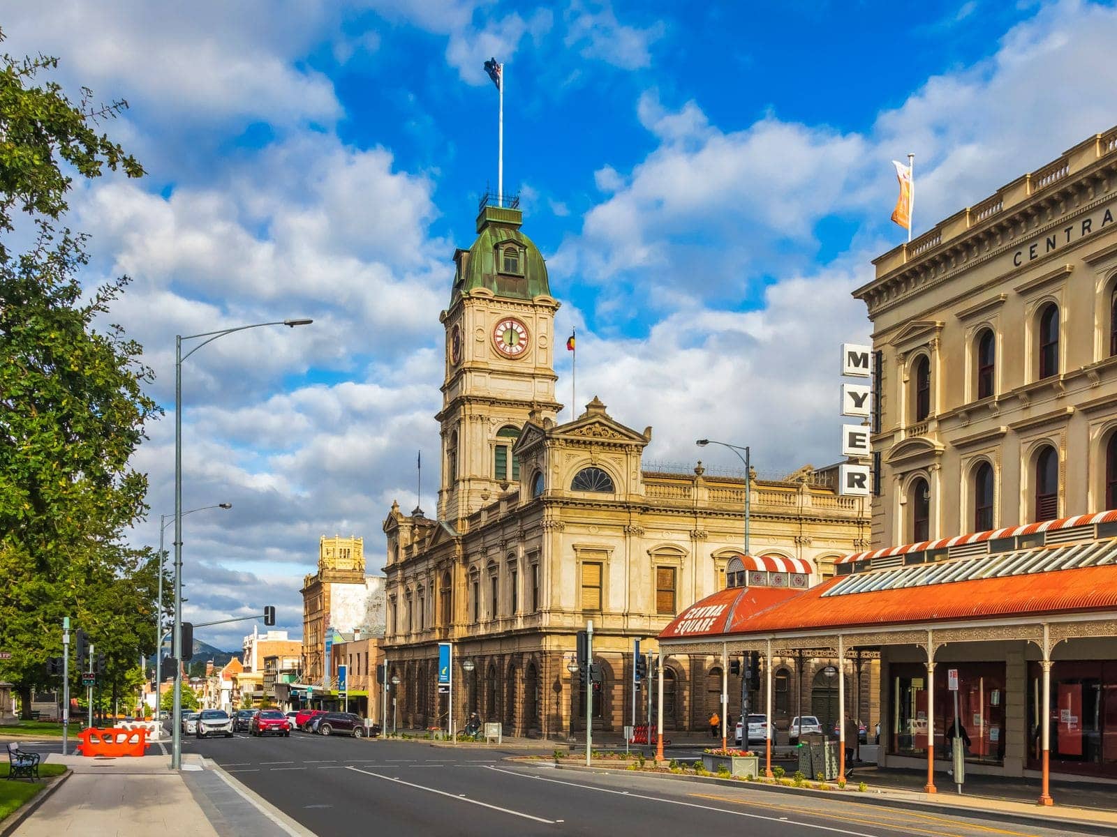 A broad Victorian-era main street with a clock-tower town hall and shopfront verandahs